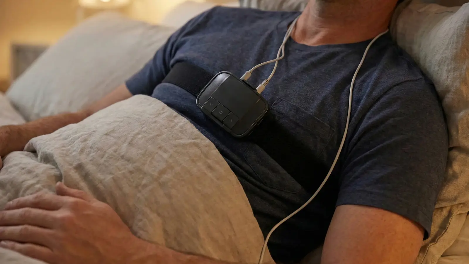 Patient mit mobilem Screening-Gerät zur häuslichen Diagnose von Schnarchen und Atemaussetzern (Schlafapnoe).
